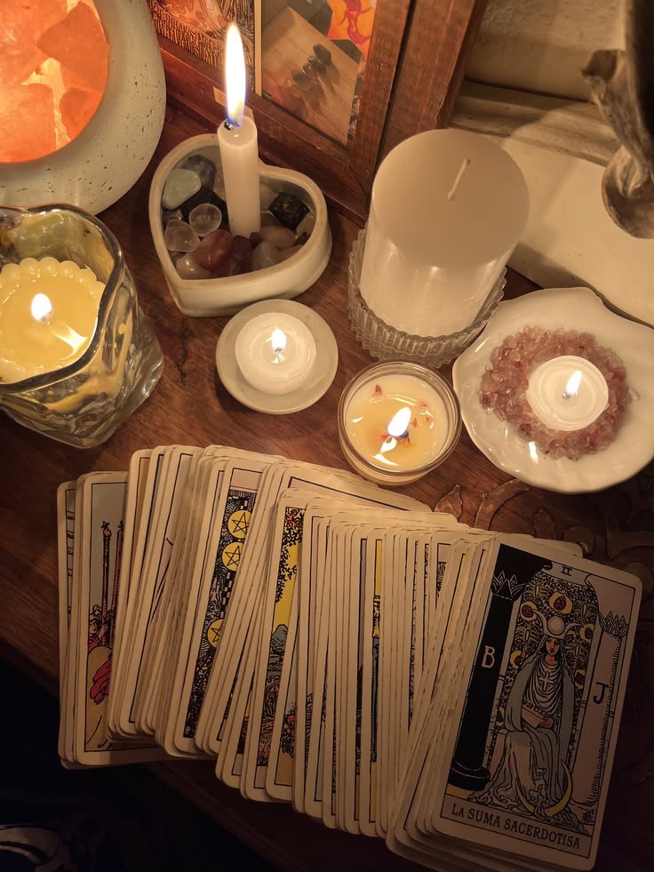 Cartes de tarot disposées entre bougies et cristaux